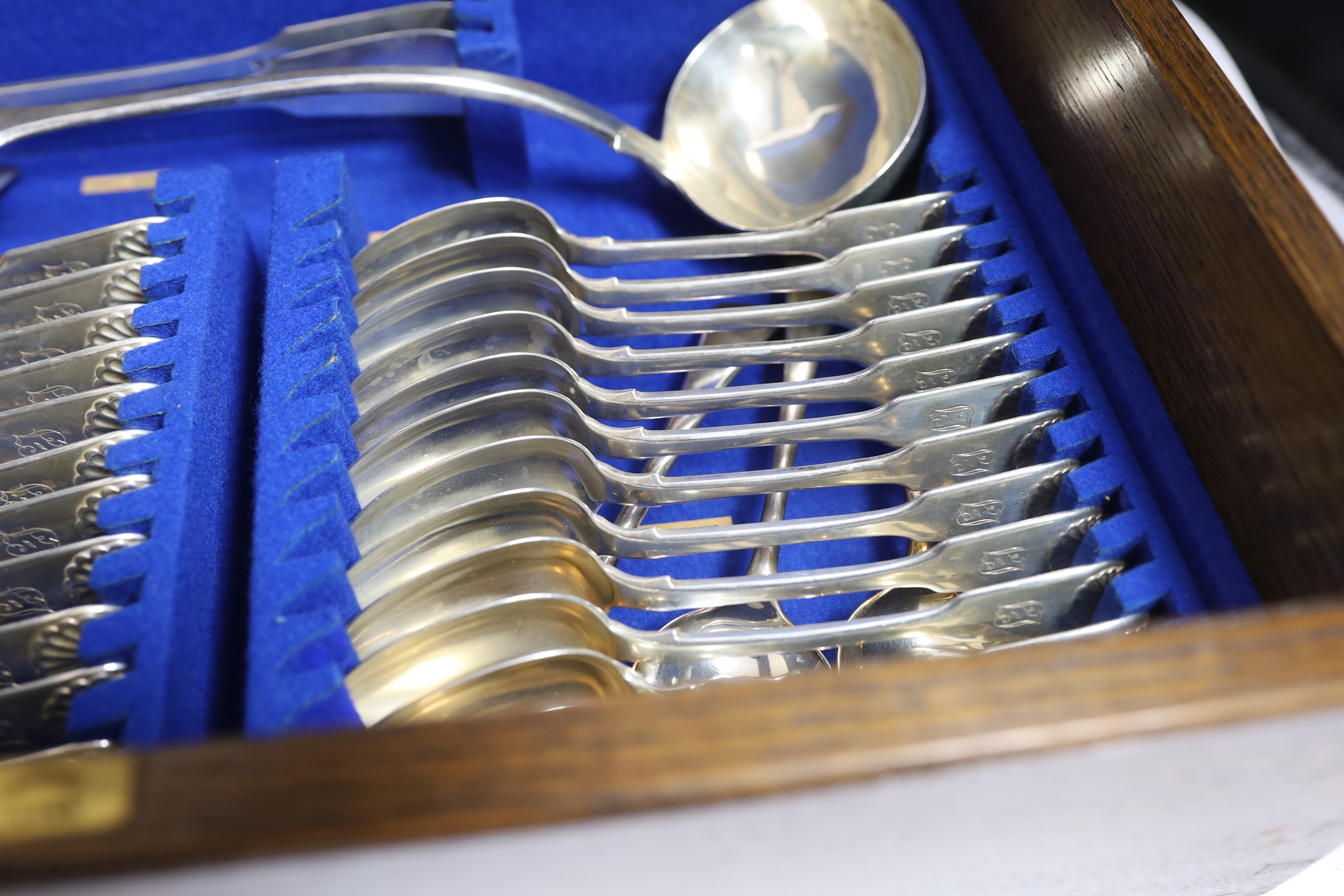 A Victorian oak cased matched canteen of silver fiddle and shell pattern flatware, by John & Henry Lias & H.J. Lias & Son